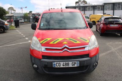 une camionnette rouge à rayures jaunes et rouges garée sur un parking