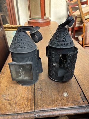 deux lanternes noires posées sur une table en bois