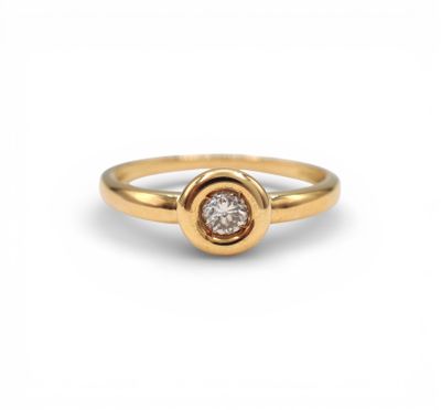 a yellow gold ring with a single diamond in the center