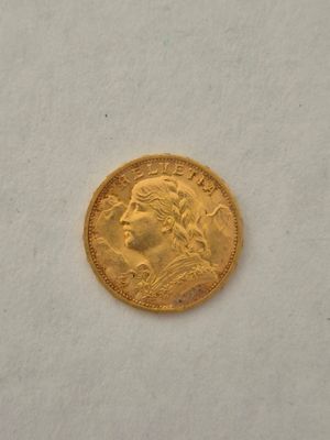 gros plan d'une pièce d'or sur une surface blanche