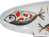 a white surfboard with two fish painted on it