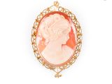 un gros plan sur le visage d'une femme dans une broche en or