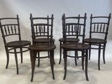 four wooden chairs sitting on top of a white sheet in front of a white backdrop