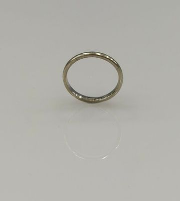 gros plan d'une bague en or sur une surface blanche