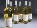 four bottles of white wine sitting next to each other on a table