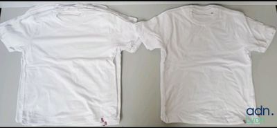 two white t - shirts sitting next to each other on a table