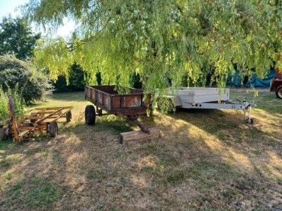 a small trailer parked under a tree in the yard