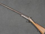 un fusil avec une crosse en bois posée sur une surface grise