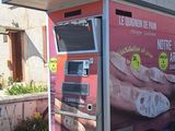 un distributeur automatique rose sur le côté d'un immeuble