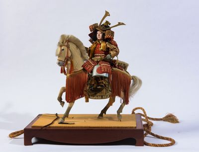 une figurine représentant un homme à cheval, posée sur un socle en bois