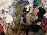a pile of clothes that is sitting on a bed