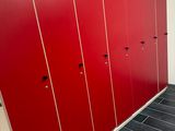 une rangée de casiers rouges dans des toilettes publiques