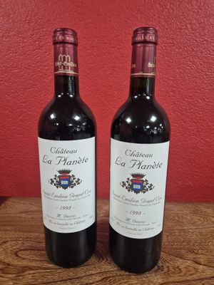 deux bouteilles de vin rouge posées sur une table en bois