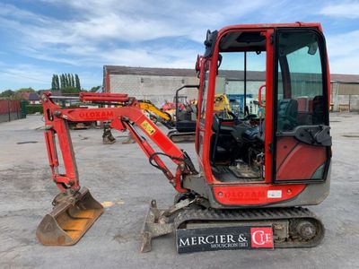 a red excavator that is parked in a parking lot