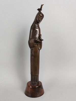 a bronze statue of a woman with a bird on her head