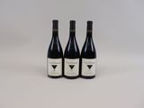 three bottles of wine sitting on top of a white table