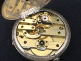 a close up of a pocket watch on a black surface