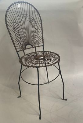 une chaise en métal posée sur une surface blanche