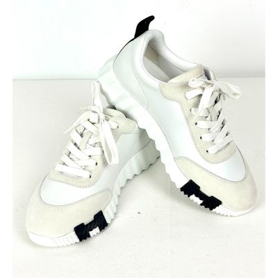 une paire de baskets blanches à semelles noires sur un fond blanc