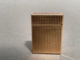a close up of a gold lighter sitting on a table