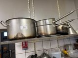 des casseroles et des poêles rangées sur une étagère dans une cuisine