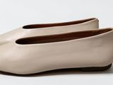 pair of women ' s shoes on a white surface with a white background