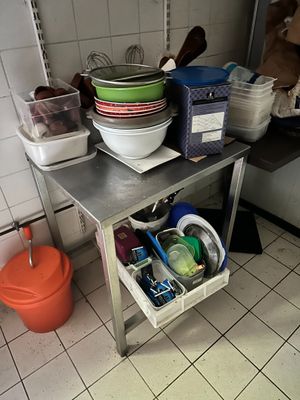 un coin cuisine équipé d'un évier et d'une table sur laquelle sont posés des bols et des casseroles