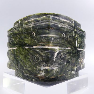 un bol en marbre vert posé sur un socle transparent