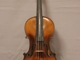 an old violin sitting on top of a white table next to a wall