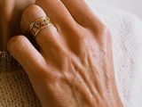 a woman with a ring on her neck and a ring on her hand