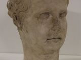 une statue représentant la tête d'un homme sur un fond blanc