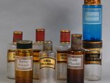 Des flacons contenant différents types de médicaments sont alignés sur une surface blanche
