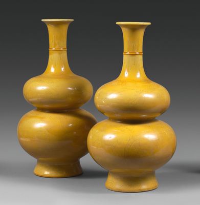 deux vases jaunes posés l'un à côté de l'autre sur une surface grise
