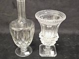 two glass vases sitting next to each other on a black surface