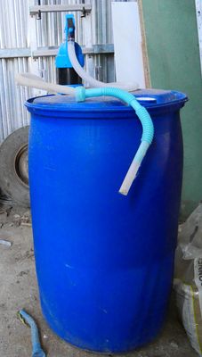a blue barrel with a pipe sticking out of it