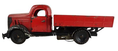 un petit camion rouge posé sur une surface blanche