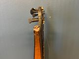 an old violin sitting on top of a wooden table next to a wall