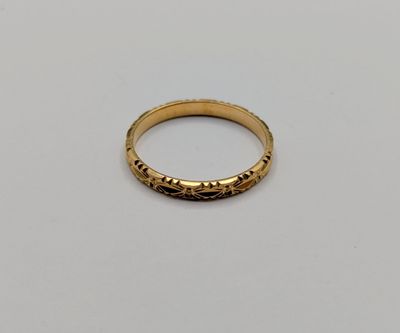 a close up of a gold ring on a white surface