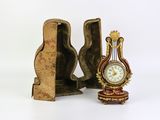 a small clock sitting next to a bookend on a white surface