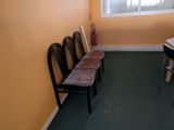 four chairs and a bench in the corner of a room