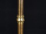 an antique brass candle holder with a lit candle on top of it