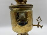 une cafetière ancienne en laiton avec une poignée, sur fond blanc