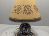 une photo d'une lampe de table bleue et dorée avec un abat-jour marron