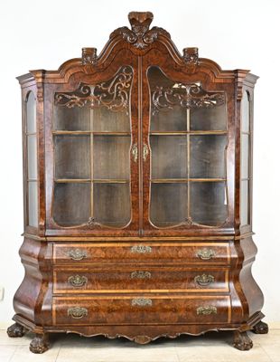 une vieille vaisselière en bois avec des portes vitrées et des sculptures ornées