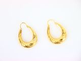 une paire de boucles d'oreilles en or sur fond blanc