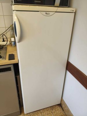 a white refrigerator in a kitchen with a microwave on top of it