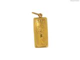 gros plan d'un pendentif en or sur fond blanc