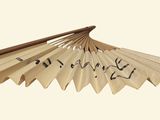 a paper fan with writing on it sitting on a table