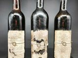 trois bouteilles de vin posées sur une table noire