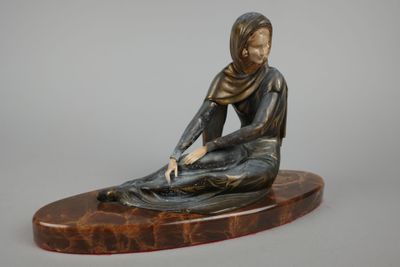 statue en bronze représentant une femme assise sur un socle en marbre